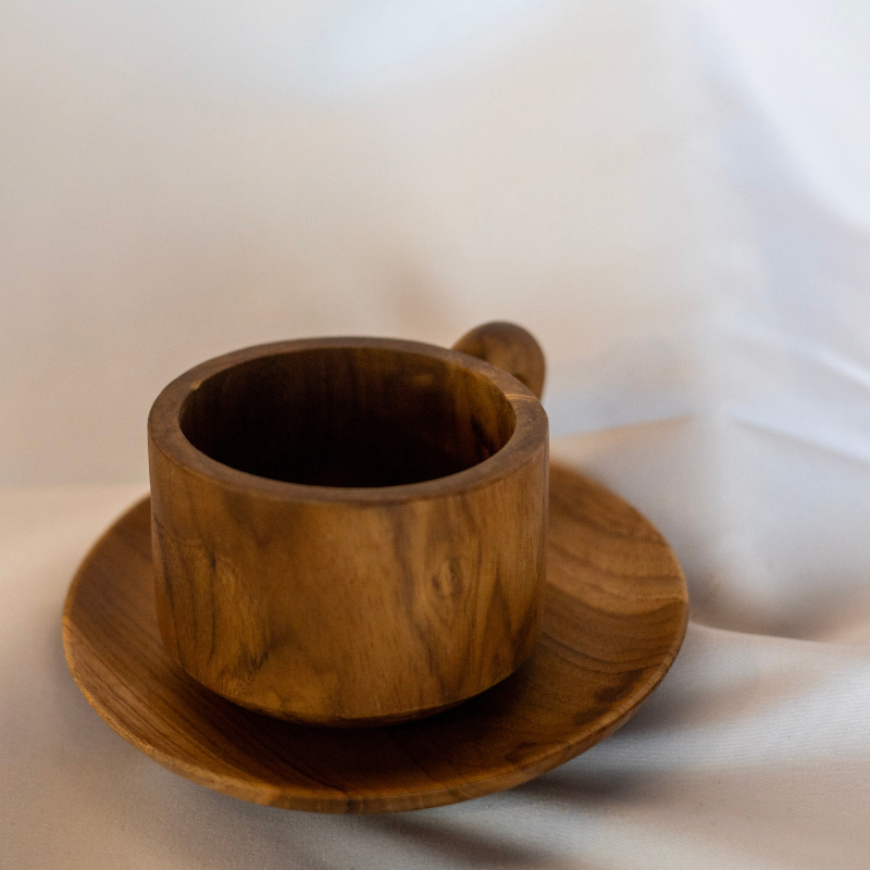 Handcrafted wooden cup and saucer set, made from natural teak wood. Features a smooth, elegant finish and ergonomic handle, perfect for serving coffee, tea, or small desserts in rustic style.