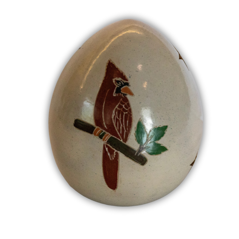 Handcrafted ceramic luminary featuring a beautifully painted cardinal perched on a branch with leaves, showcasing intricate artisan craftsmanship and a natural theme